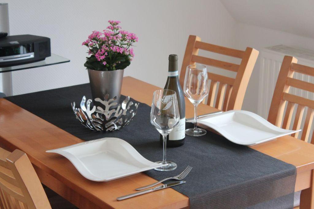- une table avec une bouteille de vin et deux verres dans l'établissement Haus Carolina, Whg. 3, à Westerland