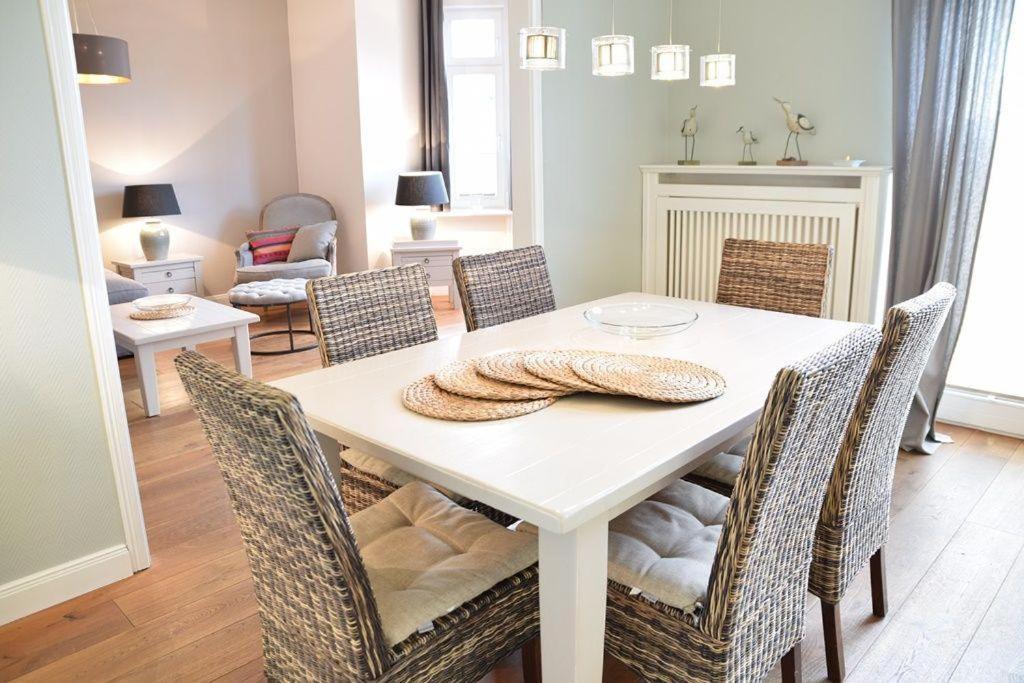 une salle à manger avec une table et des chaises blanches dans l'établissement Bundiswung 9 Whg. 2, GB2, à Westerland