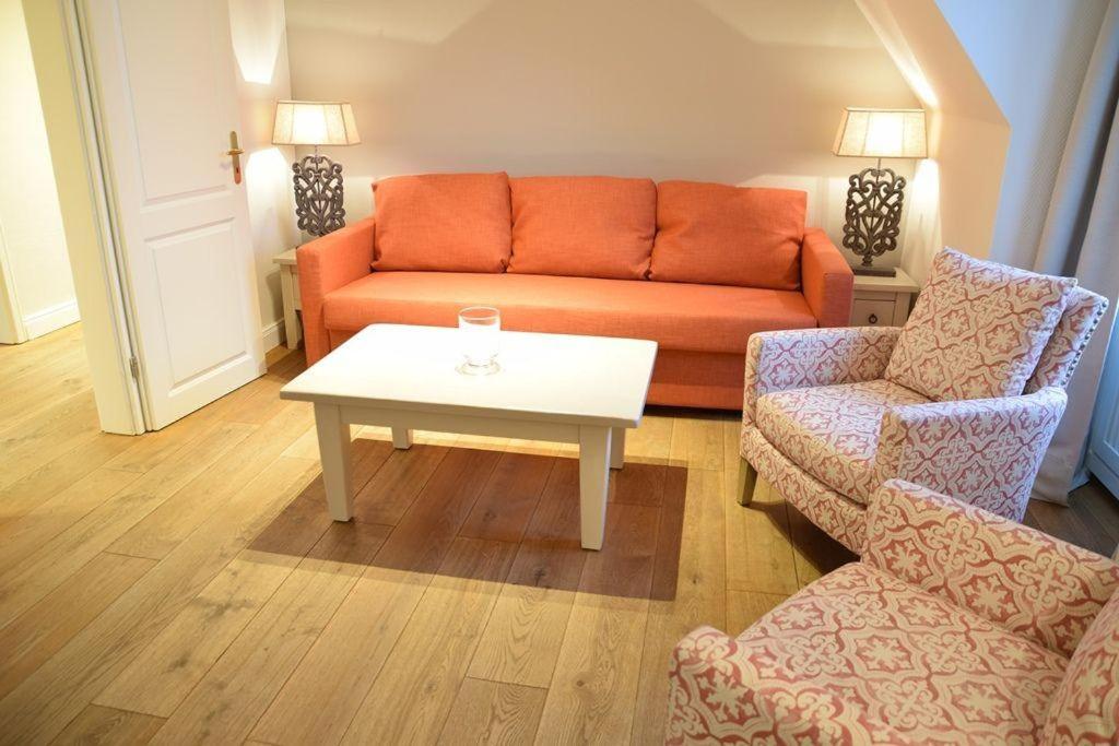 sala de estar con sofá naranja y mesa en Bundiswung 9 Whg. 4, GB2, en Westerland