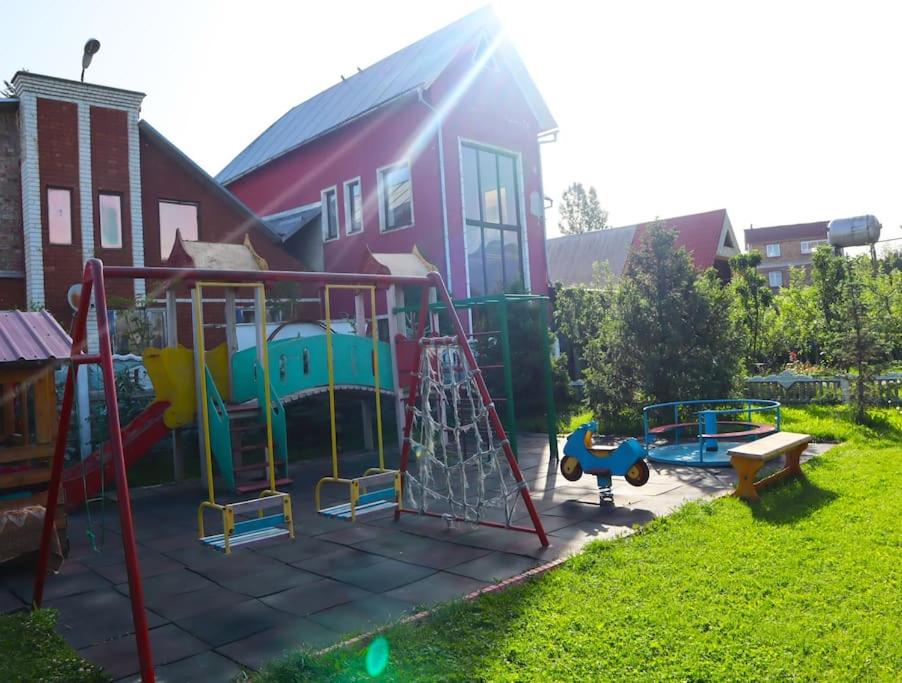 einen Spielplatz in einem Hof neben einem Haus in der Unterkunft Adorable 3 bedroom house villa with mountain view and beautiful garden in Baytyk