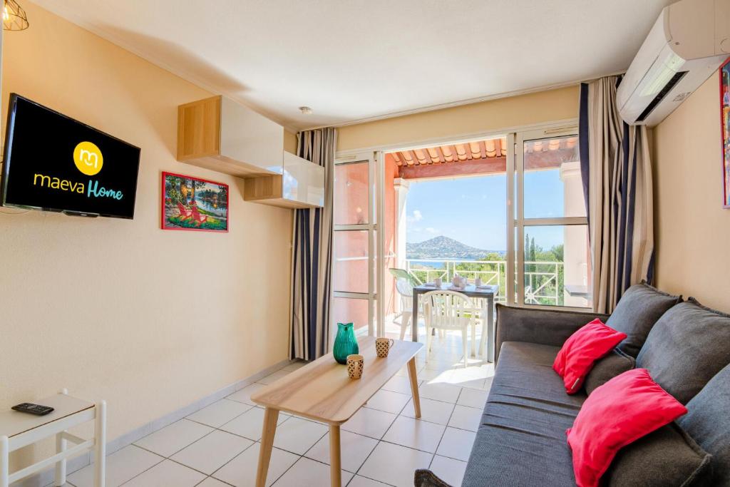 un salon avec un canapé et une table dans l'établissement Résidence le Hameau de Cap Esterel - maeva Home - Studio 4 Personnes - Sélection MAE-1064, à Saint-Raphaël