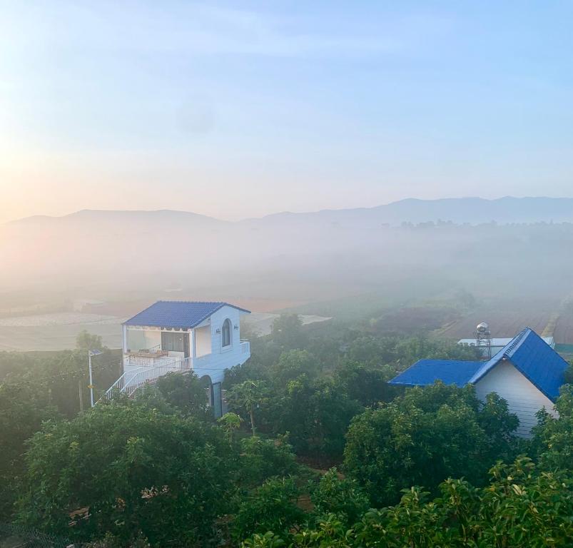 a house on top of a hill with a foggy view at Điểm du lịch canh nông Avocado Farm in Lac Nghĩa