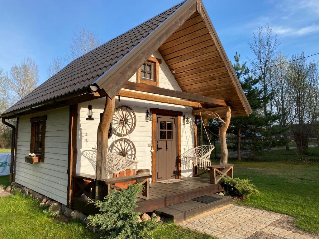 a tiny house with a porch and a staircase at Reiu majake in Reiu