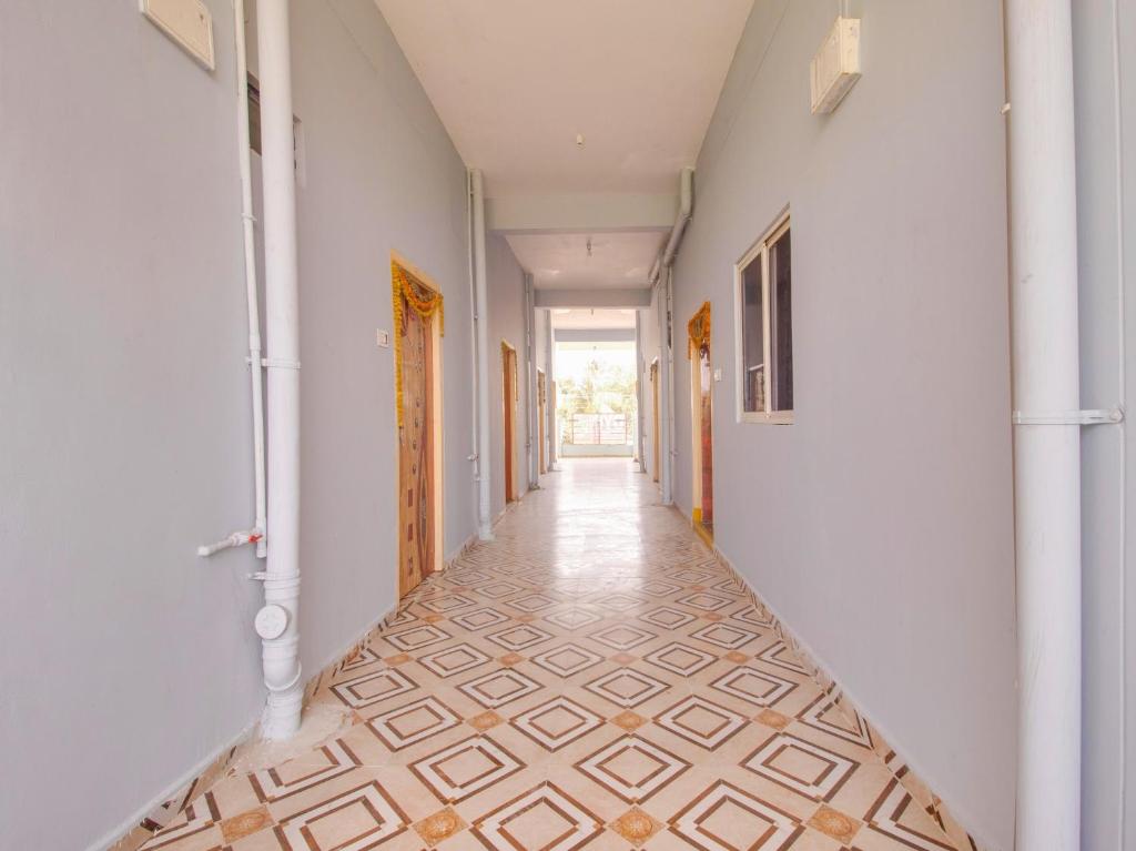 an empty hallway with a tile floor and white walls at G7 Residency in Pargi