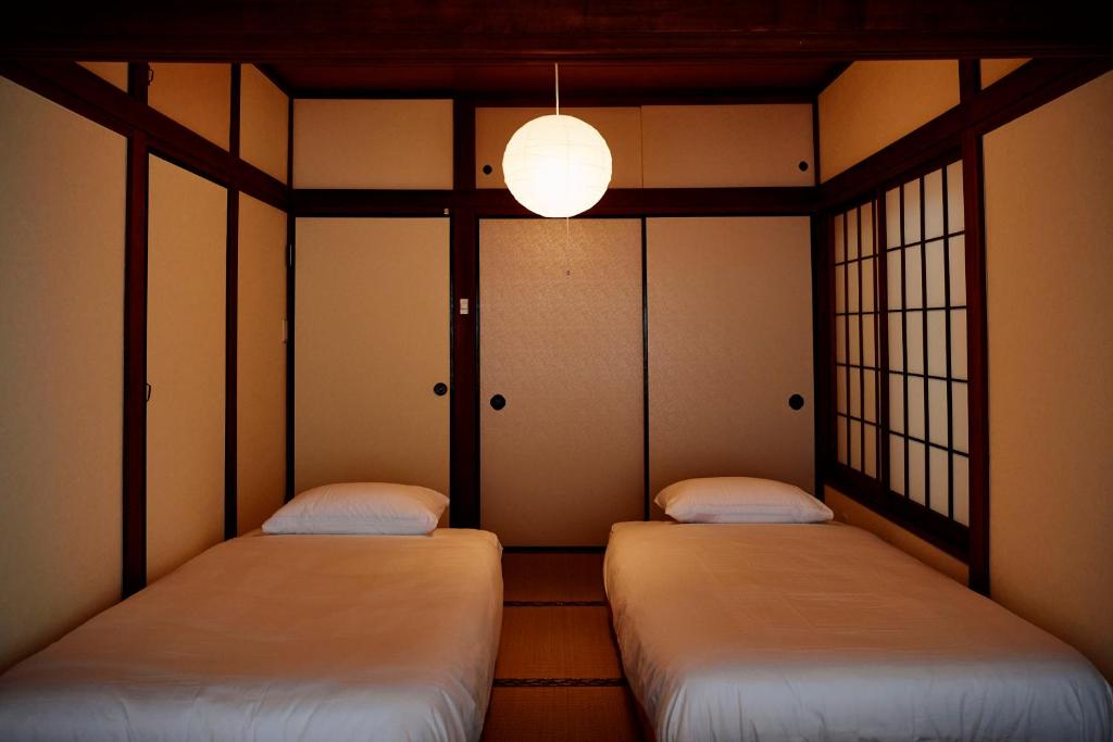 two twin beds in a room with windows at 1stop to Shibuya station Japanese traditional house in Tokyo