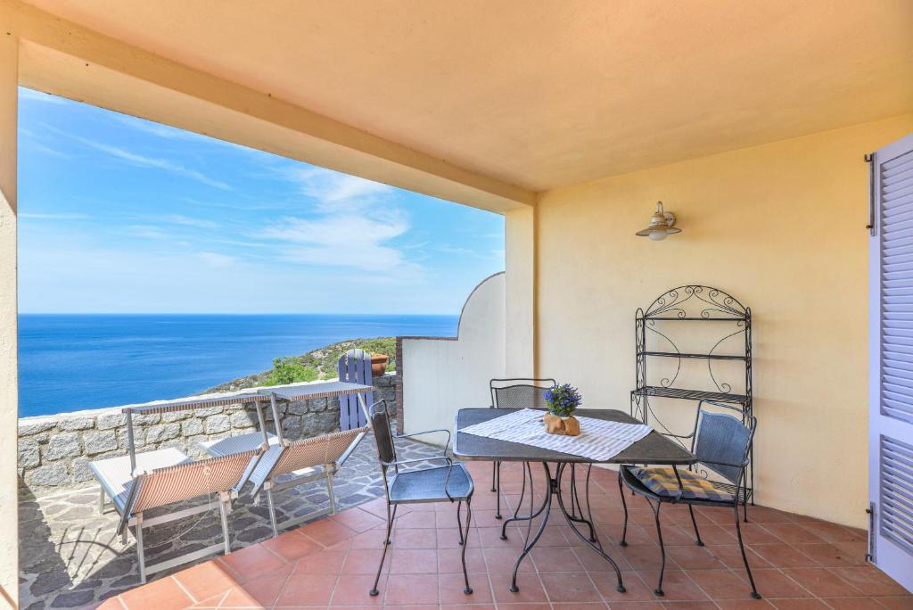 a patio with a table and chairs and the ocean at Mare e natura in Marciana