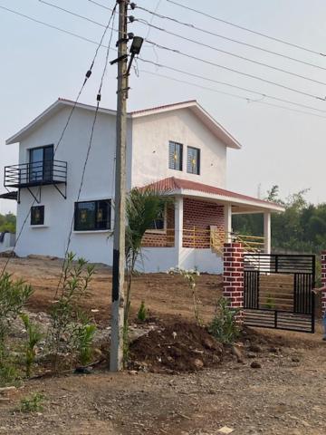 a white house with a fence in front of it at WASNIK VILLA , PLOT 16/17/18, NF-7, NEEL FARM RESORT in Nagpur