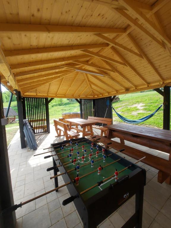 una mesa de ping pong en un pabellón con bancos en Domki pod Bukowym lasem, en Wańkowa