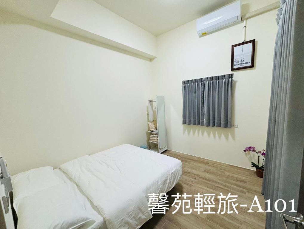 ein Schlafzimmer mit einem weißen Bett und einem Fenster in der Unterkunft 馨苑輕旅Xinyuan Guest House in Beidou