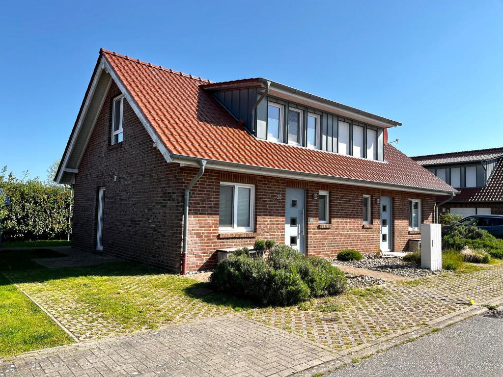 a brick house with a red roof at Ferienhaus Strandräuber in Zierow