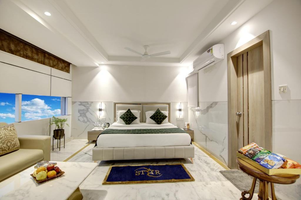 a bedroom with a king sized bed and a couch at Hotel Transit International- Aerocity Delhi Airport in New Delhi