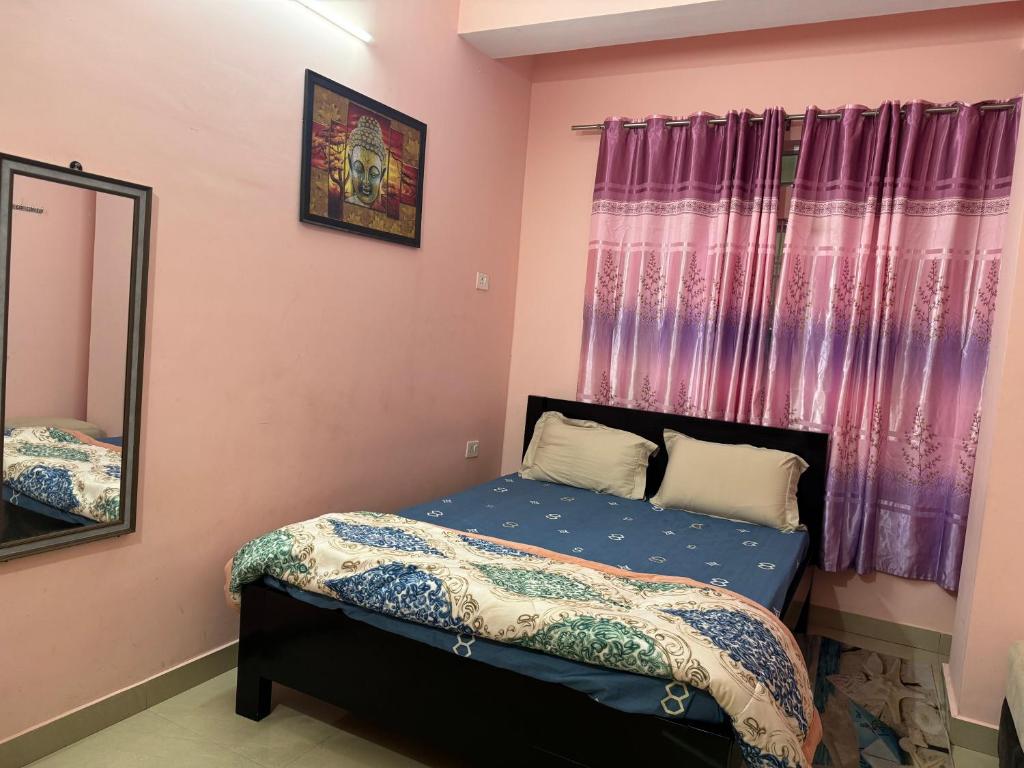 - une petite chambre avec un lit et un miroir dans l'établissement REMA HOMESTAY, à Itānagar