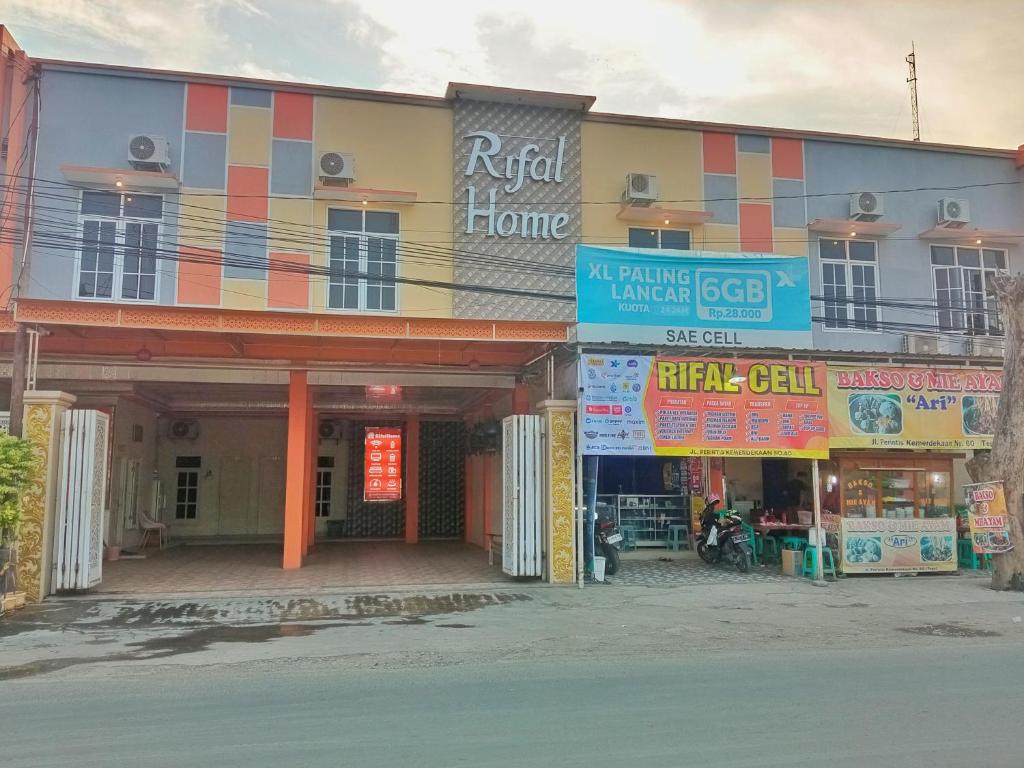 un bâtiment avec de nombreux panneaux devant lui dans l'établissement Urbanview Hotel Rifal Home Tegal, à Tegal