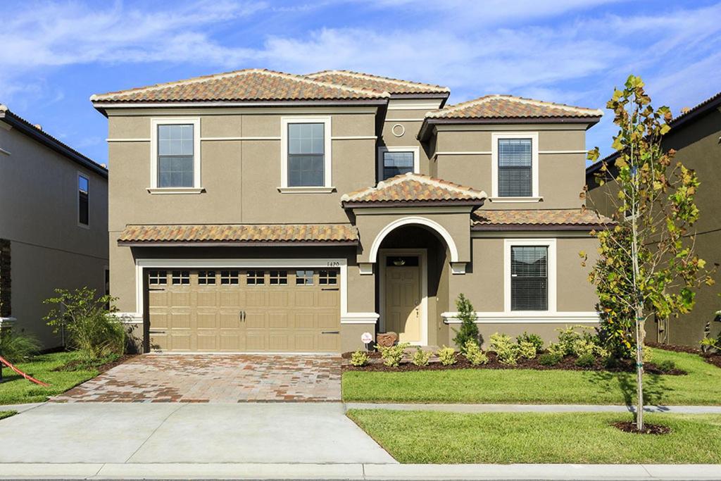 a large house with a garage in a yard at Champions Gate Villa CG014 in Orlando