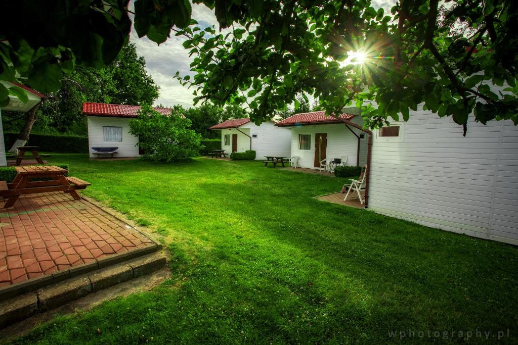 a yard with two houses and a picnic table at Agroturystyka Spokojna domek 5 osobowy in Pogorzelica