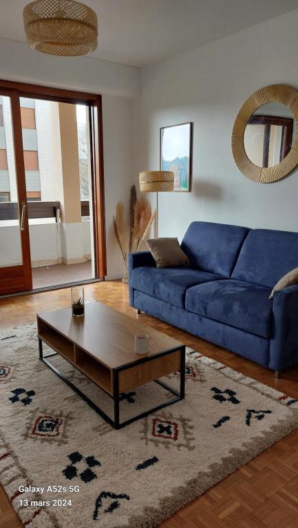 ein Wohnzimmer mit einem blauen Sofa und einem Couchtisch in der Unterkunft T2 rénové hyper centre Annecy in Annecy