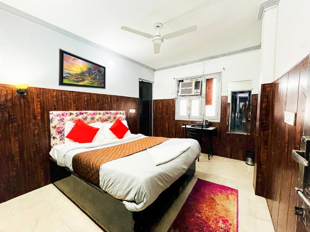 1 dormitorio con 1 cama grande con almohadas rojas en Hotel Commodo Premium Near Us Embassy Chanakyapuri en Nueva Delhi
