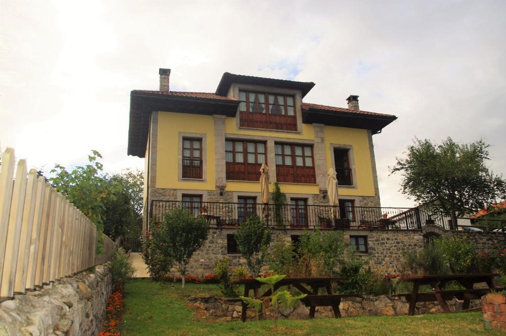 una casa amarilla con una valla delante de ella en Balcón Picos de Europa, en Narciandi