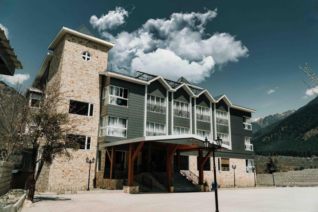 a large building with a tower on top of it at Kaizen X Voyage Resort And Spa, Manali in Manāli