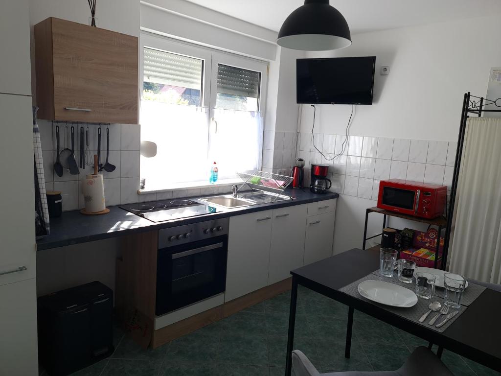 a kitchen with a sink and a stove and a table at Ferienwohnung Nauen in Nauen