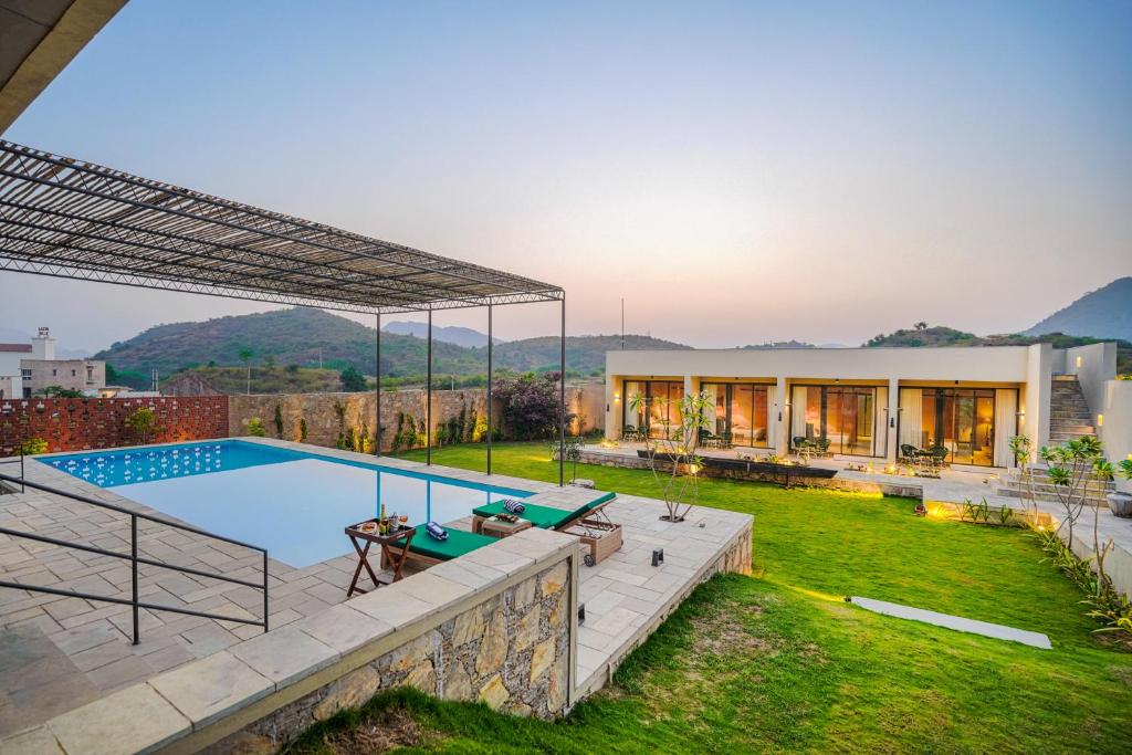 a house with a swimming pool in a yard at SaffronStays Villa Rohi in Udaipur