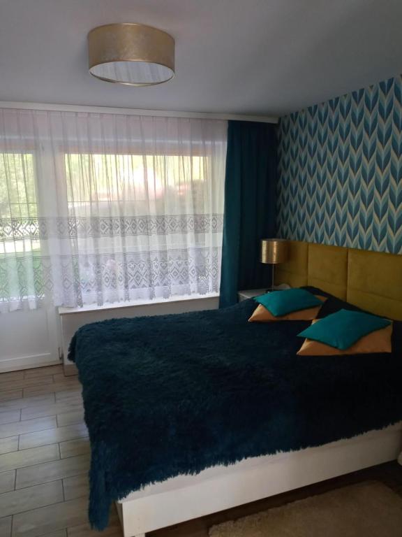 - une chambre avec un grand lit et une couverture bleue dans l'établissement Apartamenty u Darka, à Ustka