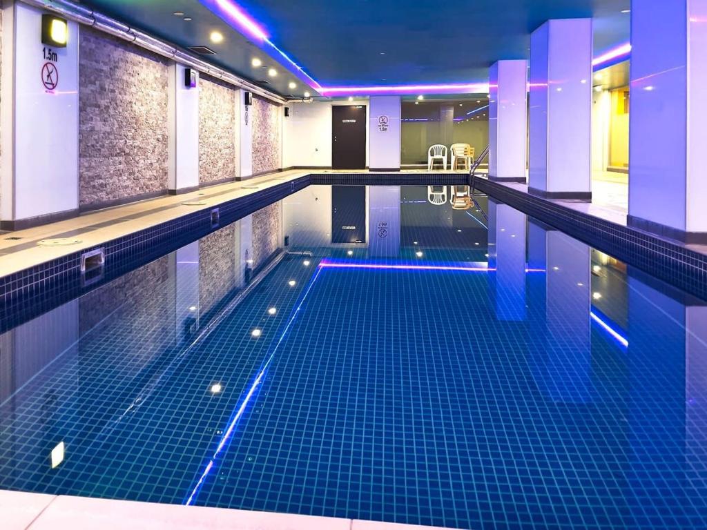 uma grande piscina com azulejos azuis num edifício em Spencer St Serenity Stylish 1-Bedroom Apartment Escape em Melbourne