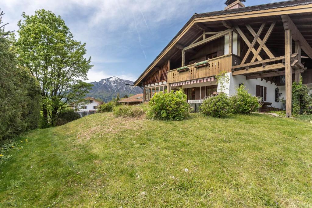 uma casa no topo de uma colina relvada em Ferienhaus mit Bergpanorama em Unterwössen