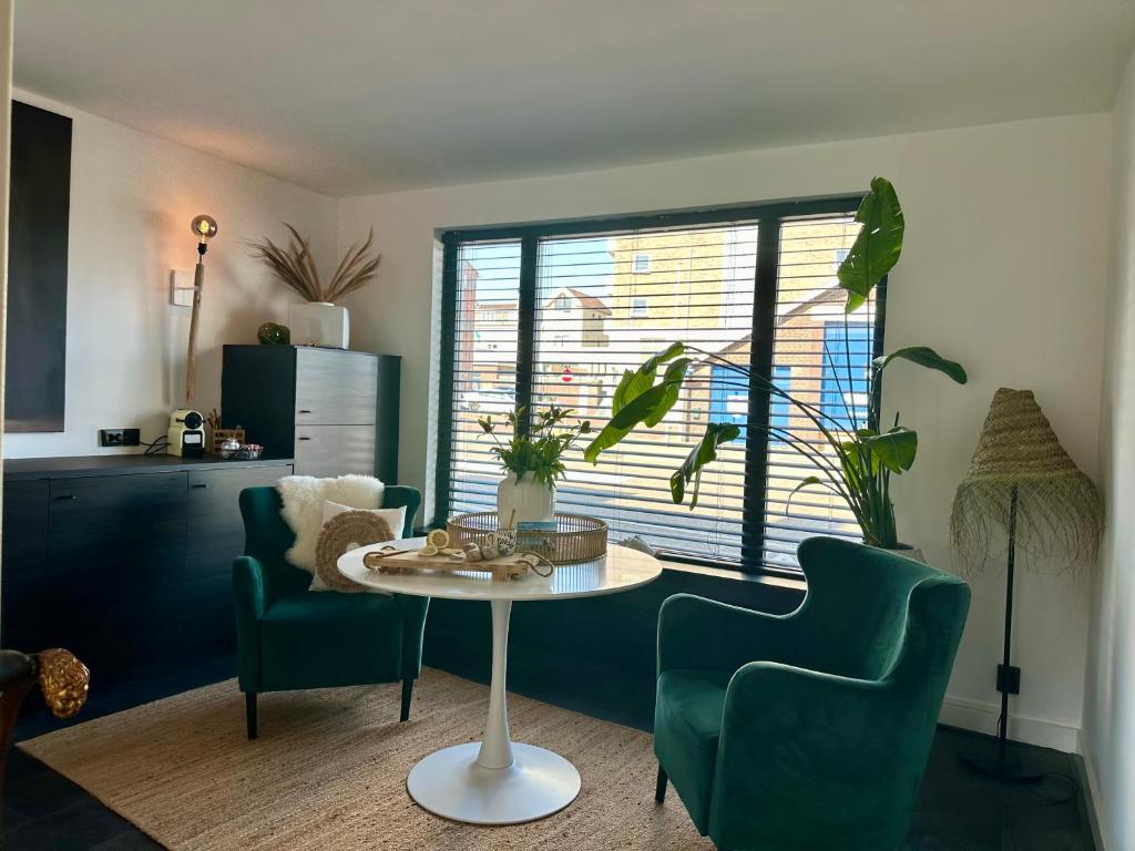 een woonkamer met een tafel en 2 stoelen bij Rembrandts Beach Suite in Zandvoort