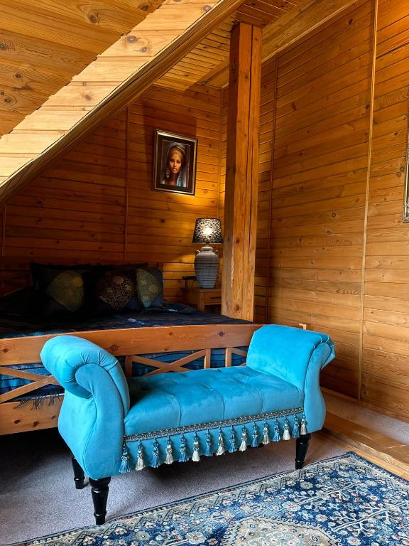 un sofá azul sentado en la esquina de una habitación en Rakši, en Cēsis
