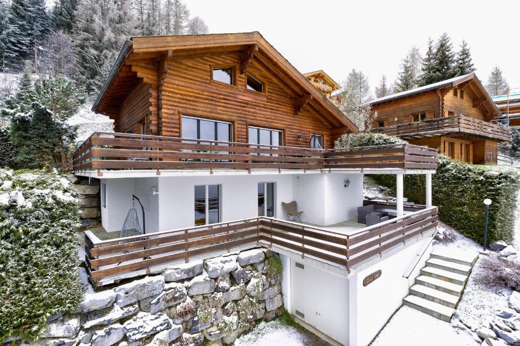 a log house with a stone wall at Chalet Coeur in La Tzoumaz