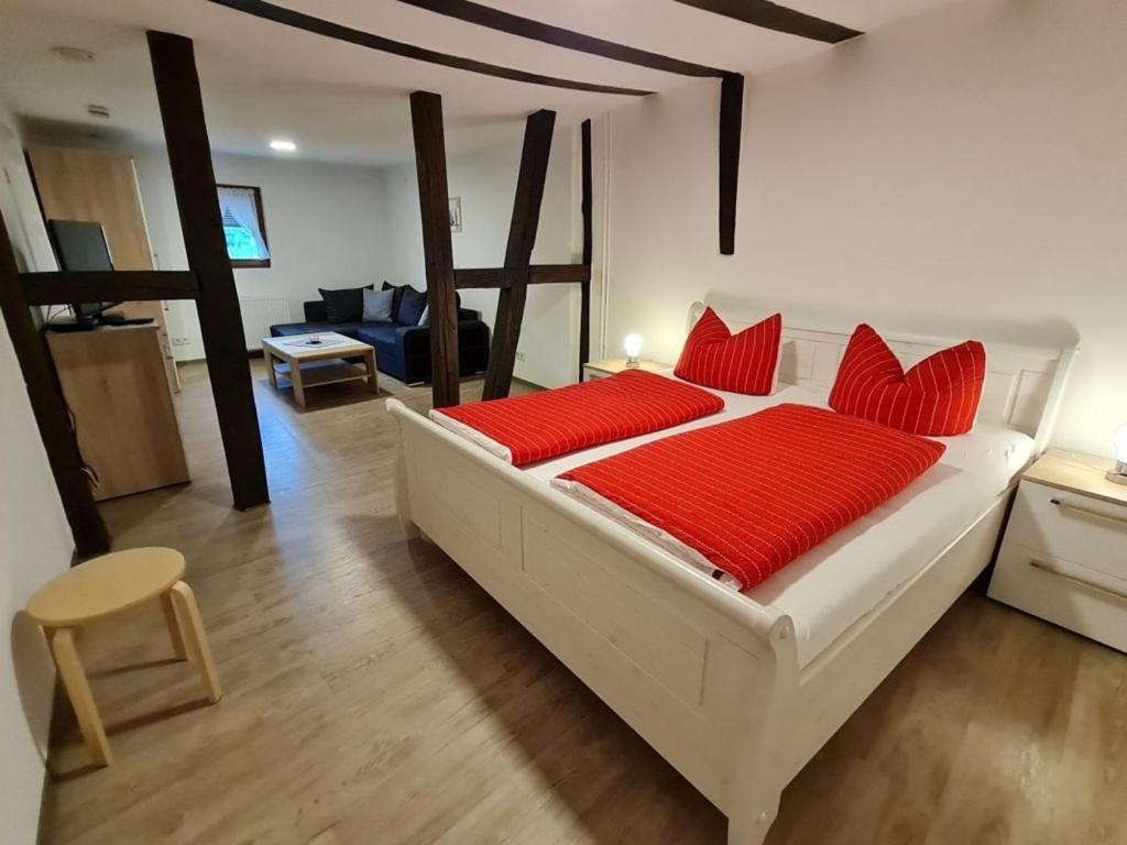 - une chambre avec un grand lit blanc et des oreillers rouges dans l'établissement Ferienhaus Fachwerkhaus mit Charme, à Bernkastel-Kues