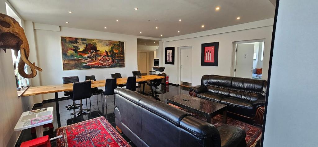 a living room with leather furniture and a table at Olsson B&B in Randers