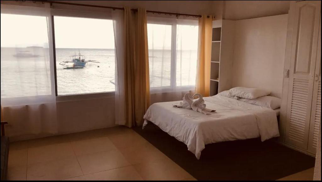 - une chambre avec un lit et une vue sur l'océan dans l'établissement Mariana Guesthouse 1 in Panagsama Beach, à Moalboal