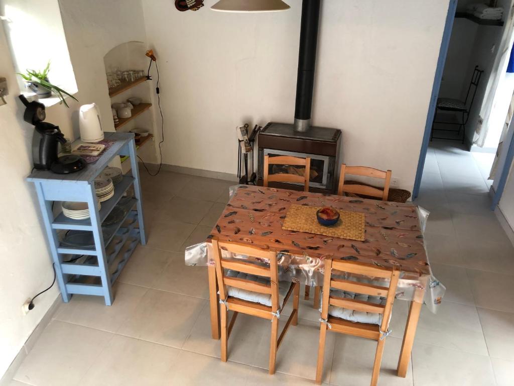 uma cozinha com uma mesa, cadeiras e um fogão em La Lauseta em Saint-Julien
