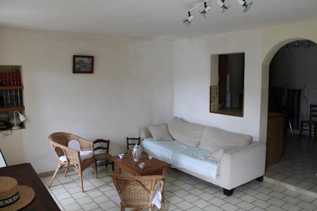 un salon avec un canapé et une table dans l'établissement Maison de Village, à Entrechaux