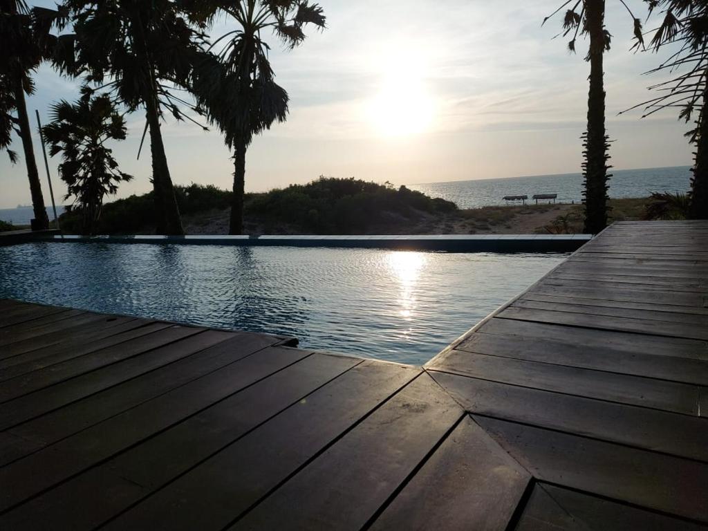 vistas a una piscina con palmeras y al océano en Majestic Beach Retreat en Kalpitiya