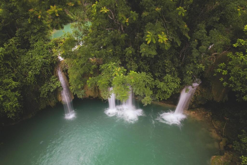 an aerial view of a waterfall in a river with trees at Homestay Bách Thảo Tà Lùng 