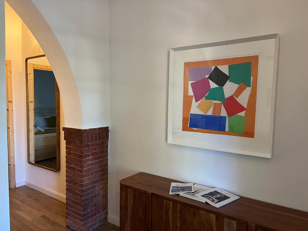 a room with a painting on the wall and a table at Maison d'Orange - La Pinede in Saint-Tropez