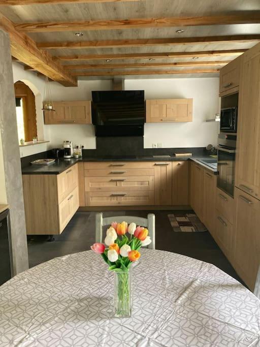 un vase de fleurs assis sur une table dans une cuisine dans l'établissement L’Happyness maison à Figaret, à Utelle