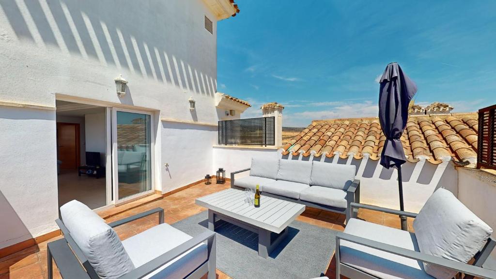 ein Wohnzimmer mit einem Tisch und einem Sonnenschirm in der Unterkunft Penthouse Egeo C-A Murcia Holiday Rentals Property in Sucina