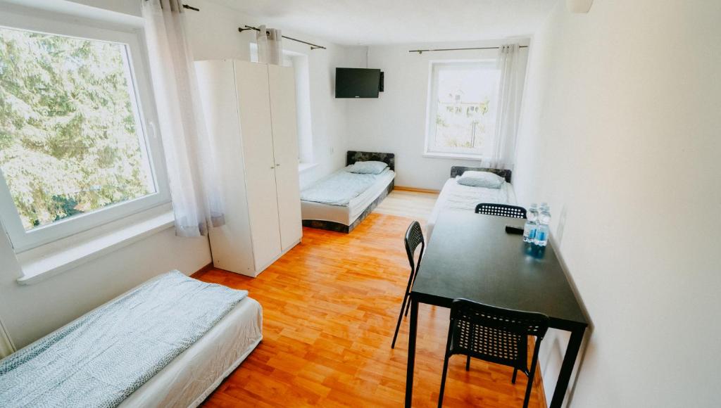 Habitación pequeña con mesa, cama y sofá en Noclegi WOKU, en Świebodzice