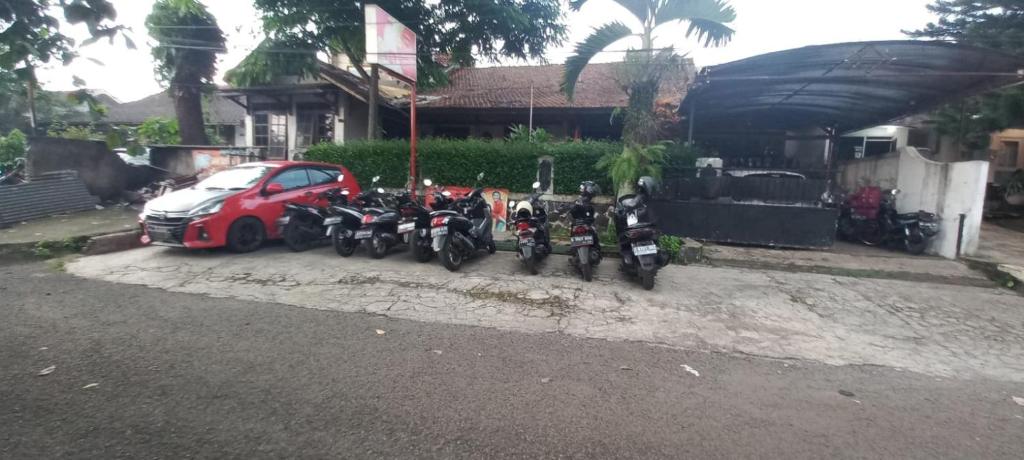 grupa motocykli zaparkowanych obok samochodu w obiekcie SPOT ON 93964 Guest House Pak Gatot 3 w mieście Bandung