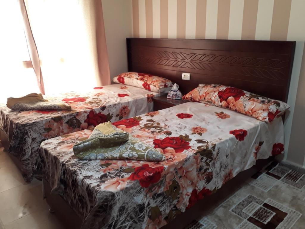 a bedroom with two beds with flowers on them at 5 stars Studio Aqua View North coast in Borg El Arab