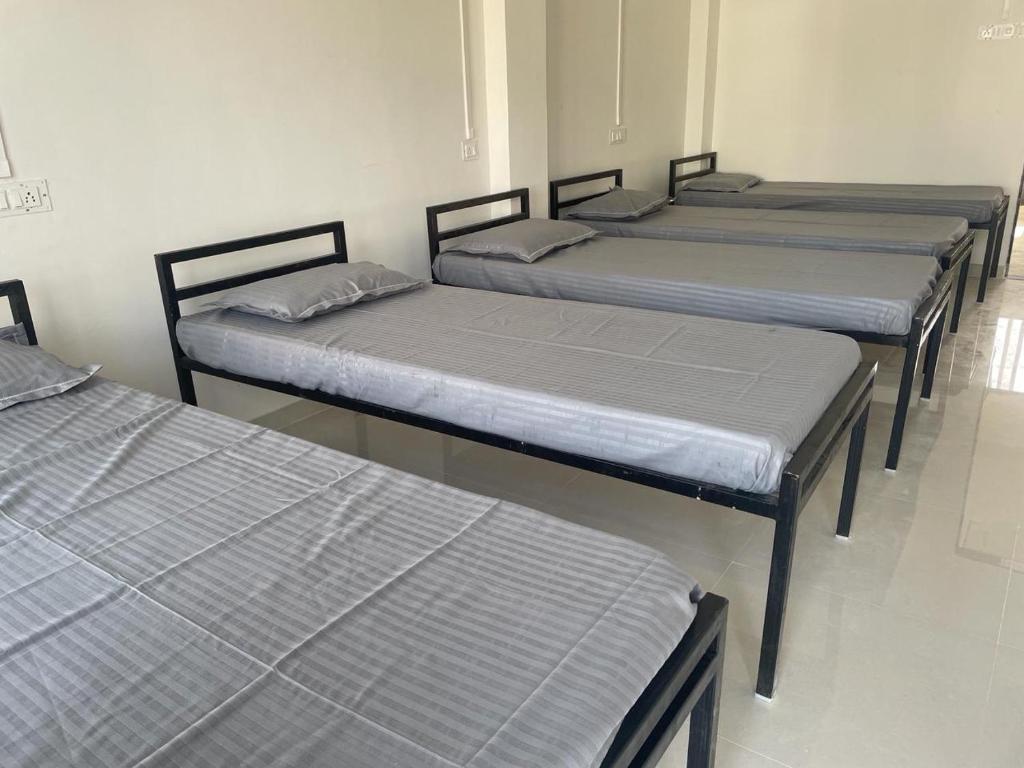 Postel nebo postele na pokoji v ubytování Dormitory & PG Times World Althan