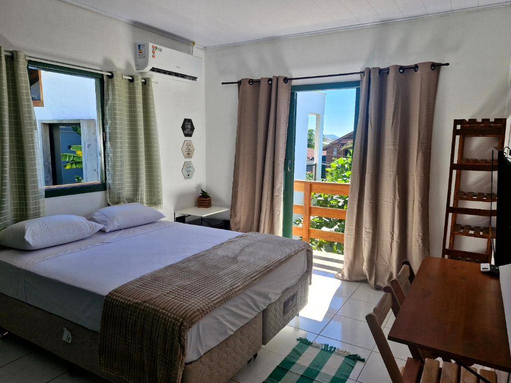 ein Schlafzimmer mit einem Bett und einem großen Fenster in der Unterkunft Pousada Makani Kai in Florianópolis