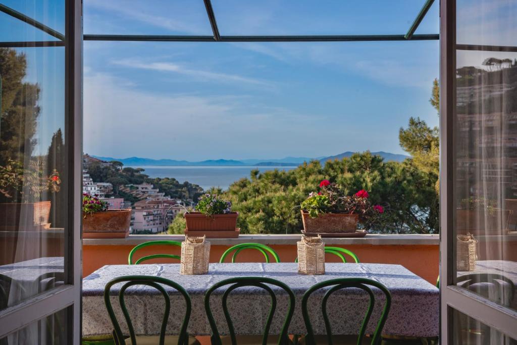 a table with chairs on a balcony with a view at [Porto S. Stefano] Elegant House + Swimming Pool in Porto Santo Stefano