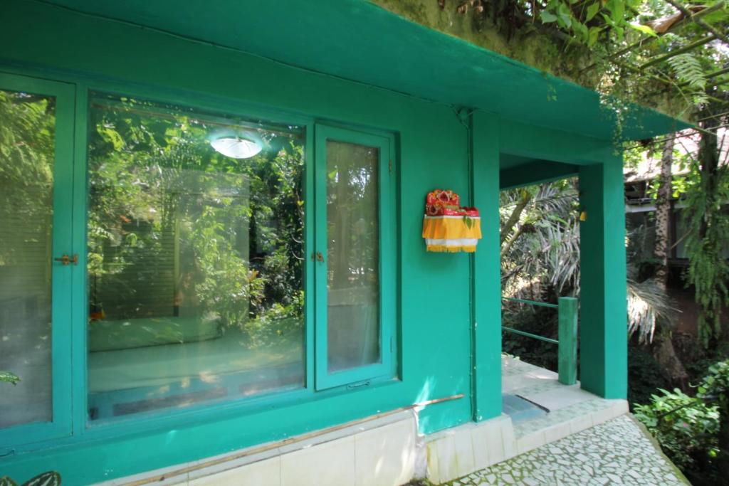 ein grünes Haus mit einem Fenster in der Unterkunft Belvilla 93915 Bamboo Villa Near Central Ubud in Ubud