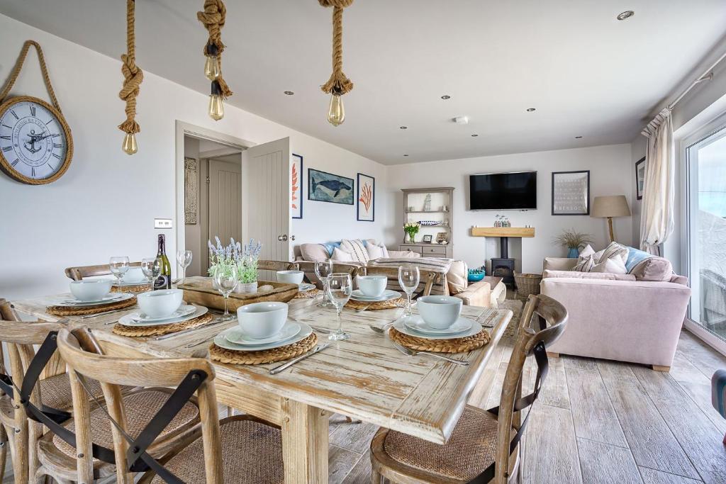 a dining room and living room with a table and chairs at Gwendy in Abersoch