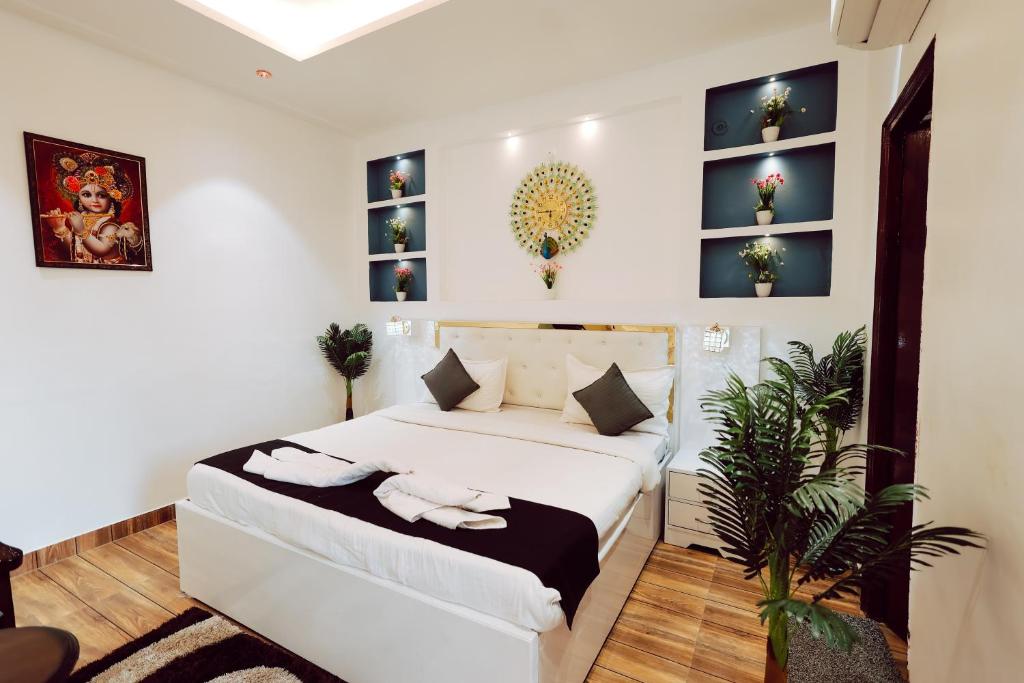 a bedroom with a white bed and a plant at Elegance Resort in Vrindāvan